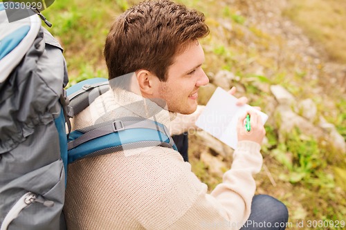 Image of smiling man with backpack hiking