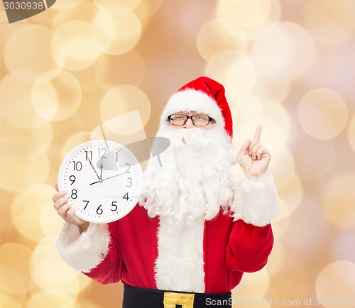 Image of man in costume of santa claus with clock