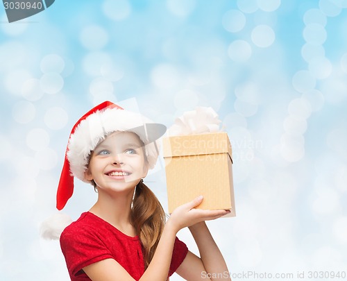 Image of smiling girl in santa helper hat with gift box