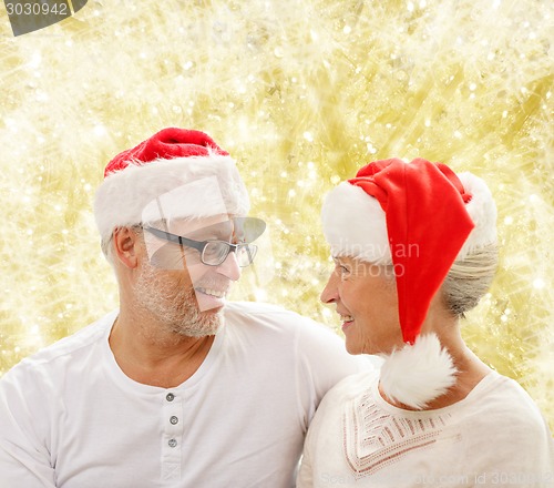Image of happy senior couple in santa helper hats
