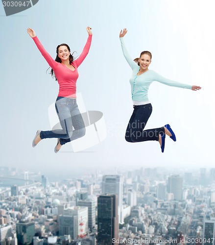 Image of smiling young women jumping in air