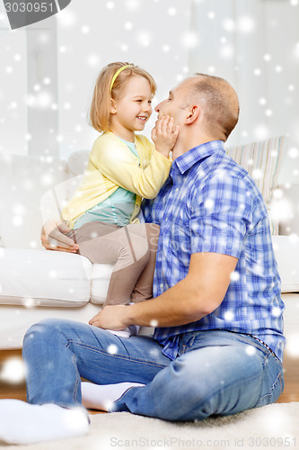 Image of smiling father and daughter hugging at home