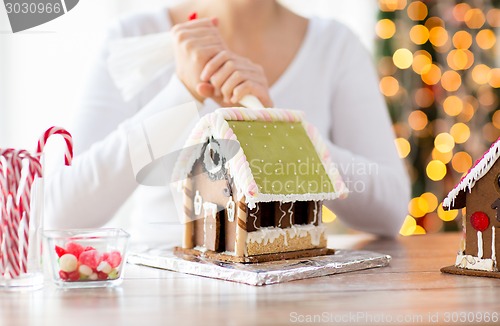 Image of close up of woman making gingerbread houses