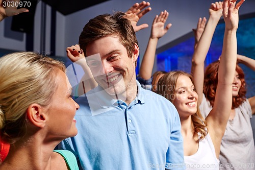 Image of smiling friends at concert in club