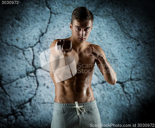 Image of young man in fighting or boxing position