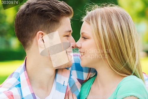 Image of smiling couple touching noses in park