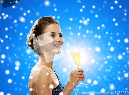 Image of smiling woman holding glass of sparkling wine