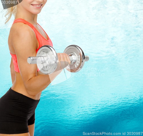 Image of close up of sporty woman with heavy steel dumbbell