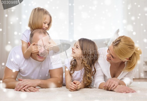 Image of smiling parents and two little girls at home