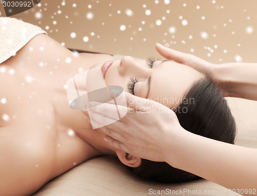 Image of beautiful woman getting face or head massage