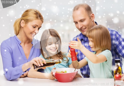 Image of happy family with two kids making salad at home