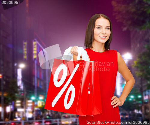 Image of young woman in dress with red shopping bags