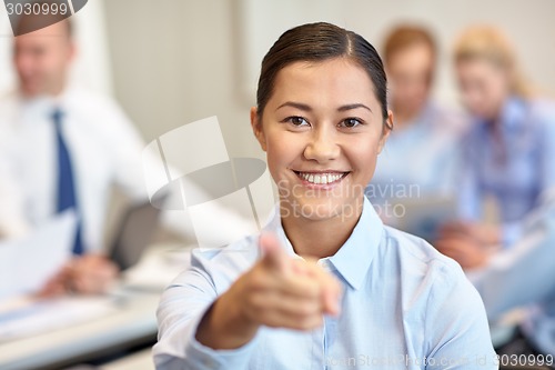 Image of group of smiling businesspeople meeting in office