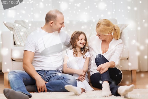 Image of smiling parents and little girl at home