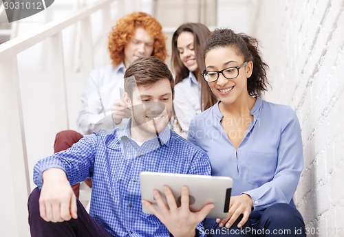 Image of team with tablet pc computer sitting on staircase