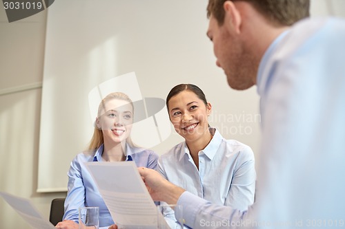 Image of group of smiling businesspeople meeting in office