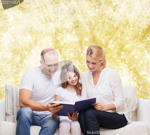 Image of happy family with book at home
