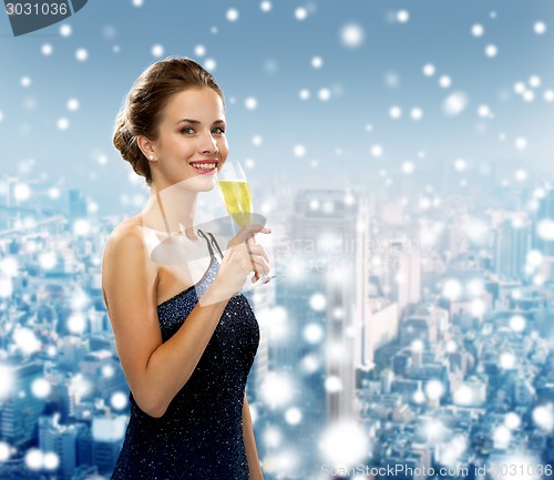 Image of smiling woman holding glass of sparkling wine