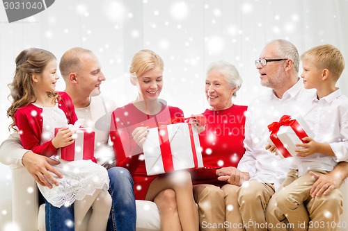 Image of smiling family with gifts at home