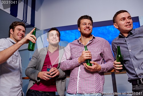 Image of group of male friends with beer in nightclub