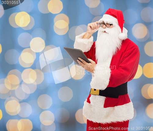 Image of man in costume of santa claus with tablet pc