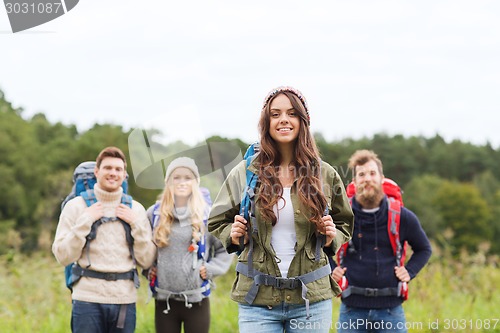 Image of group of smiling friends with backpacks hiking