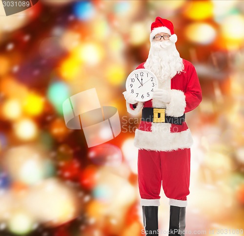 Image of man in costume of santa claus with clock