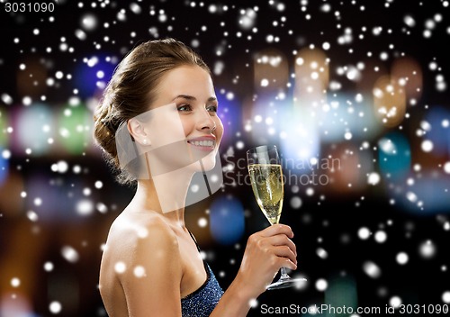 Image of smiling woman holding glass of sparkling wine