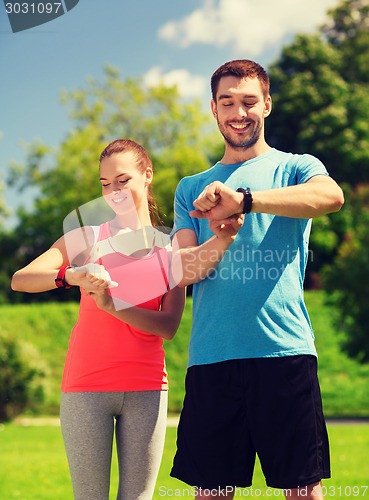 Image of smiling people with heart rate watches outdoors