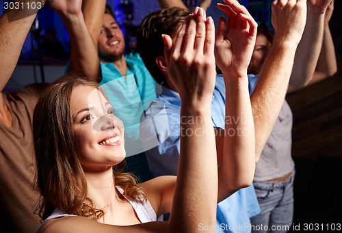 Image of smiling friends at concert in club