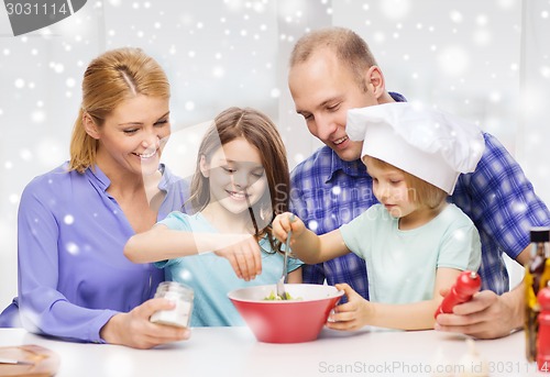 Image of happy family with two kids making salad at home