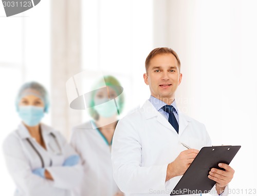 Image of smiling male doctor with clipboard