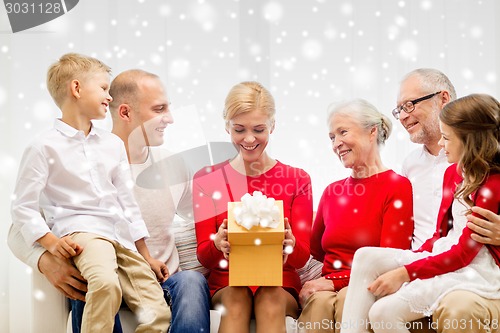 Image of smiling family with gift at home