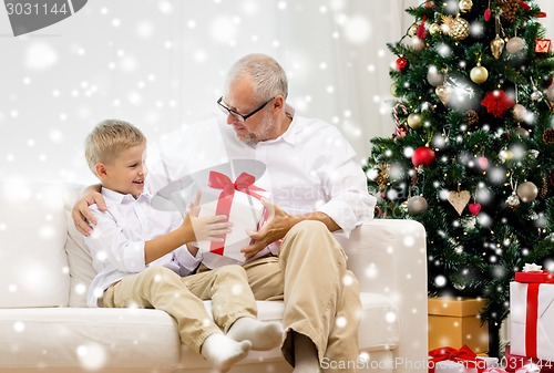 Image of smiling grandfather and grandson at home