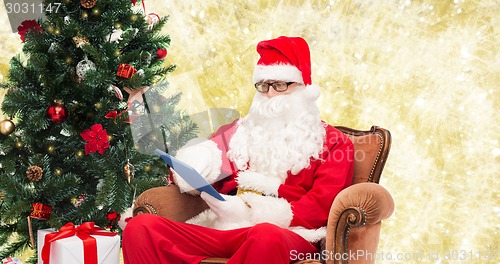 Image of man in costume of santa claus with tablet pc