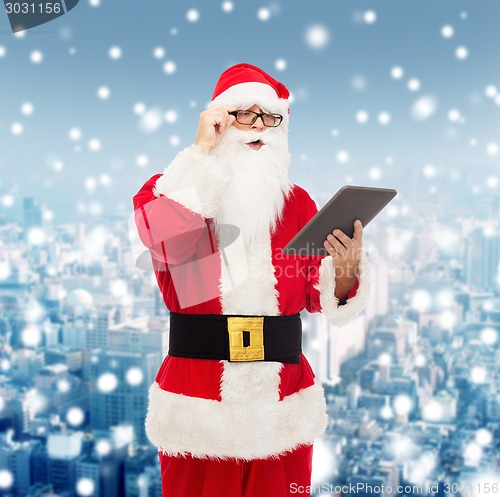 Image of man in costume of santa claus with tablet pc