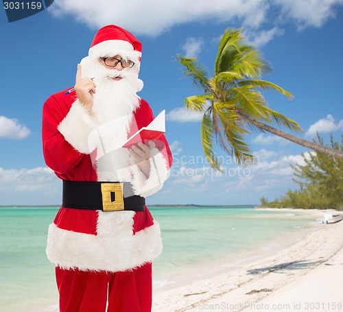 Image of man in costume of santa claus with notepad