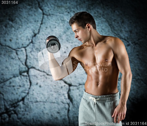 Image of young man with dumbbell flexing biceps