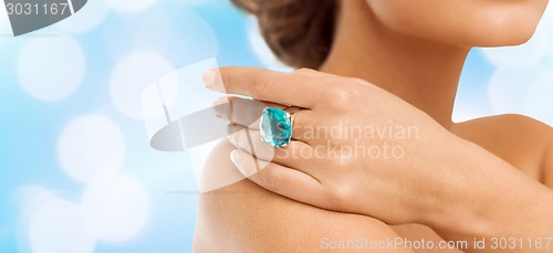 Image of closeup of woman hand with big blue cocktail ring