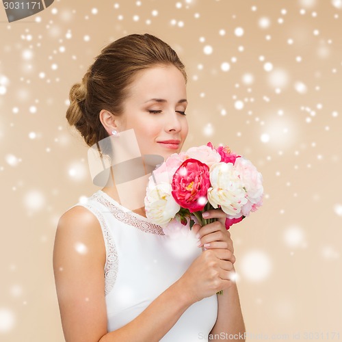 Image of smiling woman in white dress with flowers