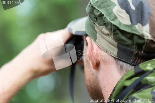 Image of close up of soldier or hunter with binocular