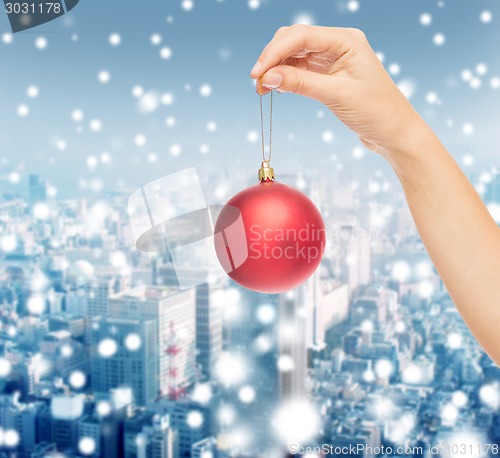 Image of close up of woman in sweater with christmas ball