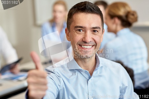 Image of group of smiling businesspeople meeting in office