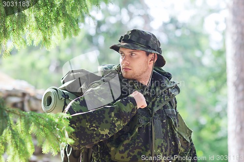 Image of young soldier with backpack in forest