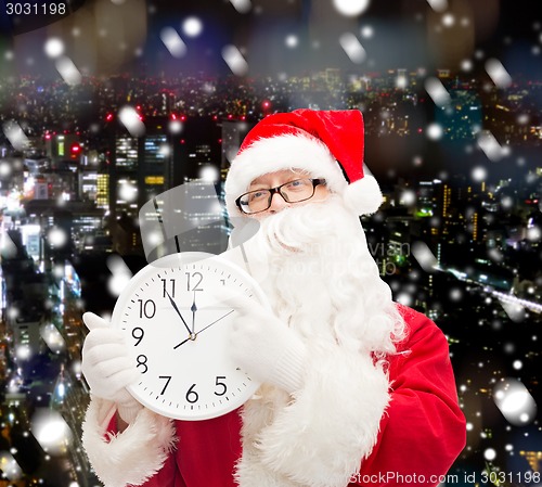 Image of man in costume of santa claus with clock