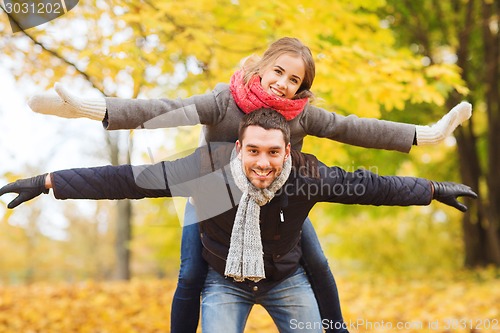 Image of smiling couple having fun in autumn park