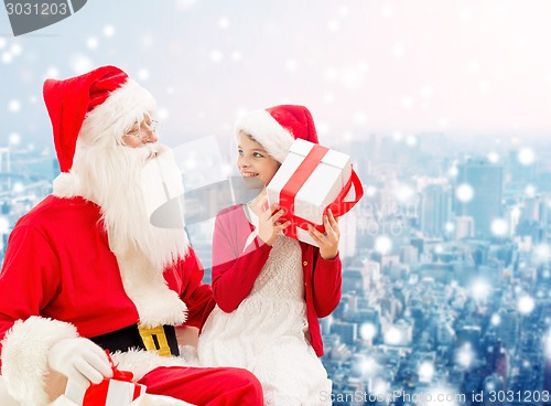 Image of smiling little girl with santa claus and gifts