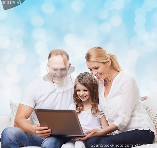 Image of smiling family with laptop