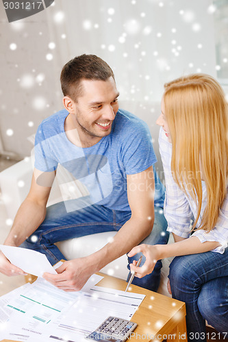 Image of happy couple with papers and calculator at home