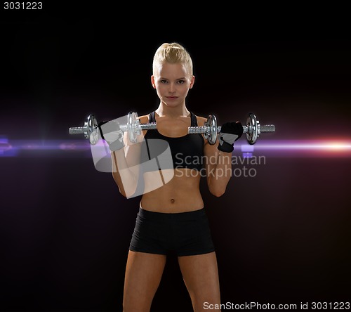 Image of sporty woman with heavy steel dumbbells